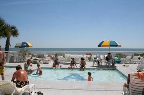 Ein Poolbereich mit Liegestühlen und Sonnenschirmen.