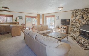 Relax in this cozy living space with a fireplace, TV, and kitchen area.