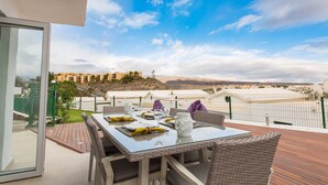 Un coin repas avec une table dressée pour quatre personnes, donnant sur un paysage pittoresque.