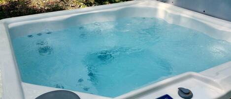 Un jacuzzi con panel de control y tapón de desagüe.