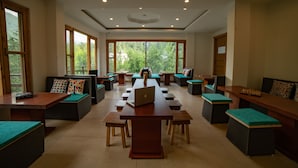 Una sala de reuniones amplia con una mesa larga, varias sillas y bancos.