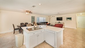 A spacious living area with a kitchen, dining table, and a red sofa. - 7 min from the strip with pool! (Las Vegas)