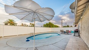 A swimming pool with a white umbrella, a patio area with chairs, and a white fence. - 7 min from the strip with pool! (Las Vegas)