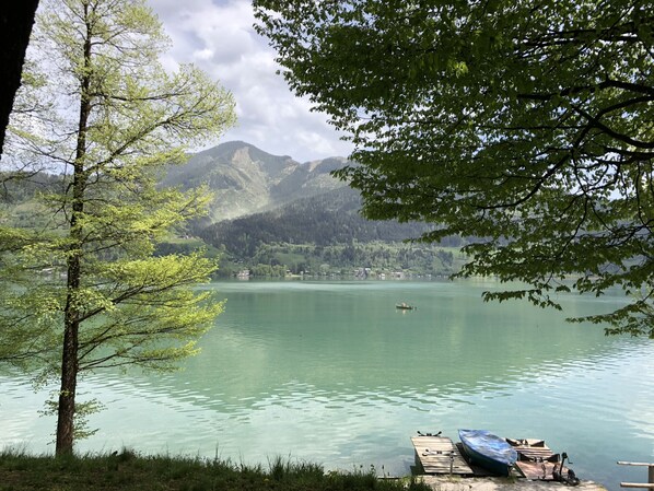 A calm lake with boats, a dock, and a mountainous backdrop. - Finest Kitzblick Golf Suites TOP 1 (Zell am See)
