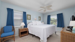 A bedroom with a bed, two nightstands, a chair, a desk, and a ceiling fan. - Tropical Garden View 2 bed, 2 bath at Sanibel Moorings #622 (Sanibel)