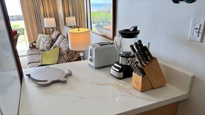 A kitchen counter with a blender, toaster, and knife block.