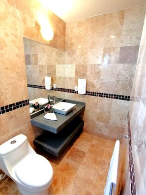 A bathroom with a toilet, sink, and mirror.