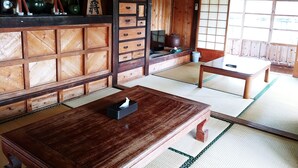 A traditional Japanese room with tatami flooring, wooden furniture, and sliding doors. - Cottage CANAC (Motobu)