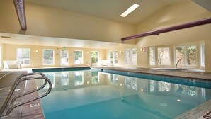 An indoor swimming pool with clear windows, a wooden deck, and a metal ladder. - Promo! Three Bedroom Oceanfront Condo, Wifi, HDTV, Hot Tub and Indoor Pool (Depoe Bay)