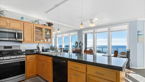 A modern kitchen with wooden cabinets, stainless steel appliances, and a large island. - Promo! Three Bedroom Oceanfront Condo, Wifi, HDTV, Hot Tub and Indoor Pool (Depoe Bay)