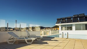 A rooftop pool area with lounge chairs and a poolside bar. - Clérigo - T2 Holiday Apartment in São Martinho do Porto By SCH (São Martinho do Porto)