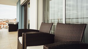 A balcony with wicker chairs and a view of buildings. - Clérigo - T2 Holiday Apartment in São Martinho do Porto By SCH (São Martinho do Porto)