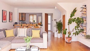 Ein modernes Wohnzimmer mit Sofa, Couchtisch und Blumentöpfen.