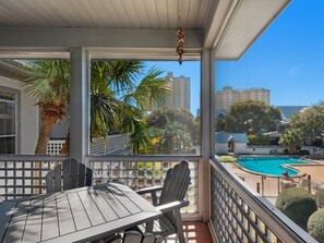 Enjoy a serene view of the pool and lush surroundings from this balcony.