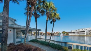 A waterfront hotel with a pool, palm trees, and a dock. - Wrap-Around Balcony, Two Swimming Pools, Walk to the Beach (Miramar Beach)