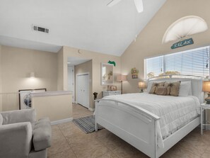 A bedroom with a bed, bedside tables, a desk, a chair, a window with blinds, and a ceiling fan. - Wrap-Around Balcony, Two Swimming Pools, Walk to the Beach (Miramar Beach)