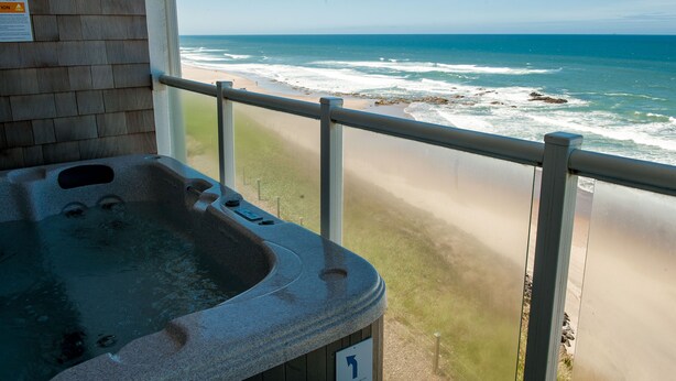 A hot tub with a view of the beach and ocean.