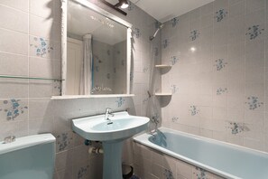 A bathroom with a pedestal sink, a bathtub, and a shower.