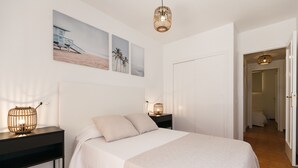 Ein Schlafzimmer mit Bett, Nachttischen und Wandbildern.