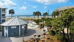 A beachfront property with a pool, lounge chairs, and a view of the ocean. - At the Beach - Gulf Views - Pool (Miramar Beach)