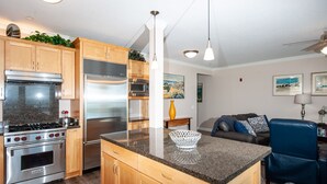 A modern kitchen with granite countertops, stainless steel appliances, wooden cabinets, and pendant lighting. - Promo! Second Floor Corner Condo, Oceanfront, Private Hot Tub, Pool, Wifi (Lincoln City)
