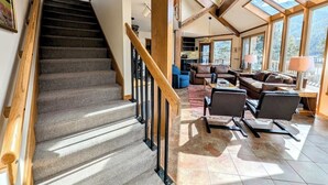 A spacious living area with a staircase leading to an upper floor, large windows, and a cozy seating arrangement. - Pet friendly (with fees) Great views (Keystone)
