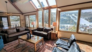 A spacious living room with a large window offering a scenic view of a snowy landscape. - Pet friendly (with fees) Great views (Keystone)