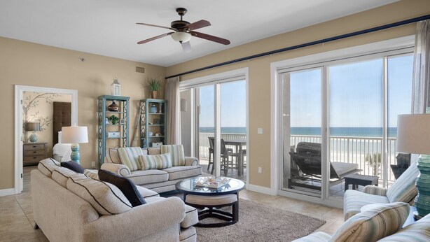 A spacious living room with a large sofa, a coffee table, and a view of the ocean through sliding glass doors. - Hear the Waves, Big Balcony, Look at the Beach, Unique, Spacious (Miramar Beach)