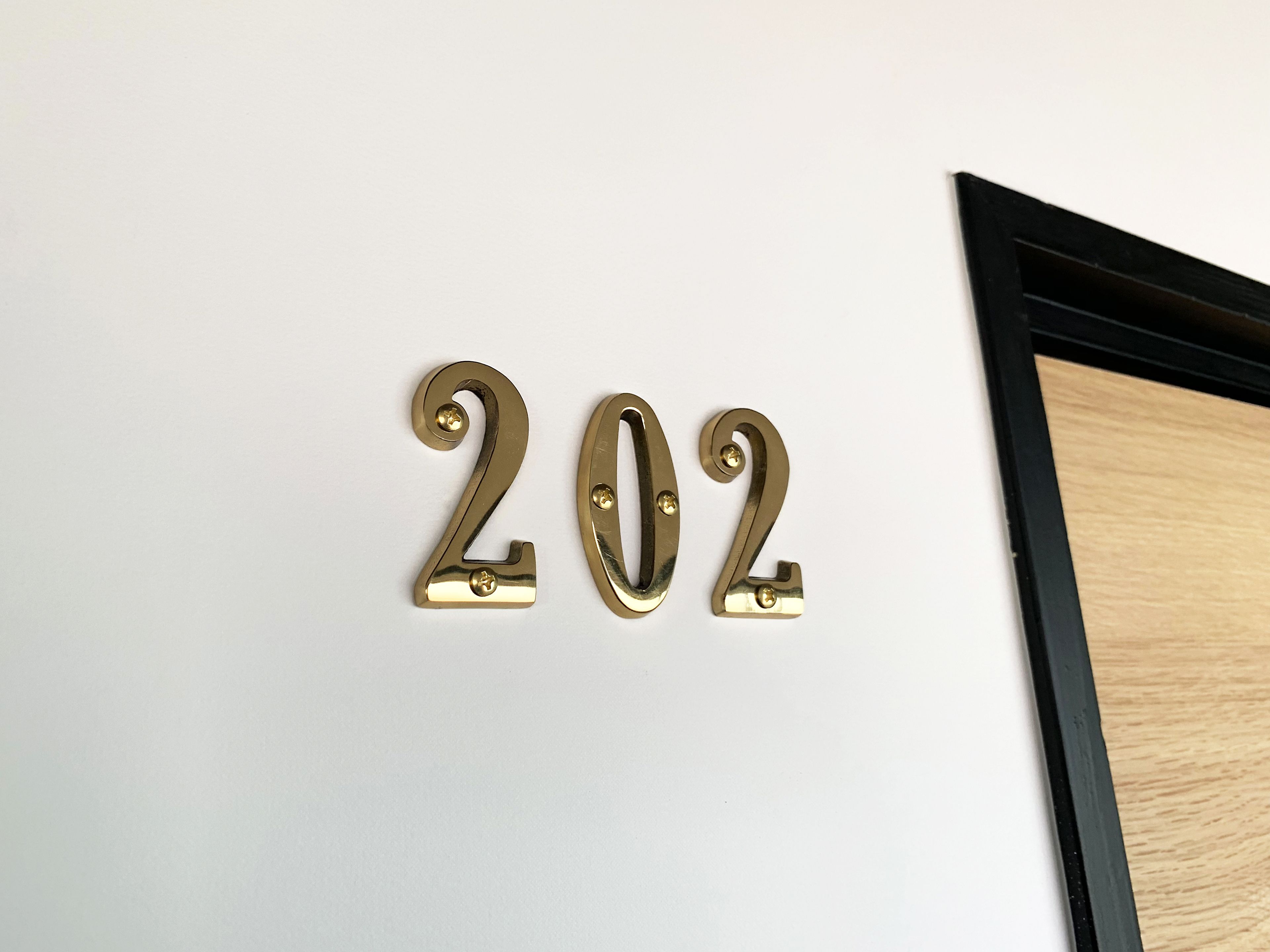 Un letrero de latón fijado a la pared con el número 202.