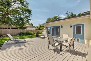 Eine Terrasse mit Gartenmöbeln, eine überdachte Veranda und ein Haus mit blauen Verzierungen.