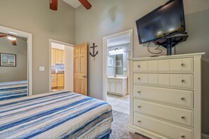 Ein Schlafzimmer mit Bett, Kommode und Fernseher.