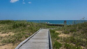 A wooden boardwalk leading to a beach with a clear sky. - FFR310 - Ocean Sky by First Flight Rentals (Kill Devil Hills, NC 27948)