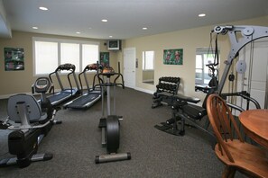 A gym with treadmills, weight machines, and a rowing machine.