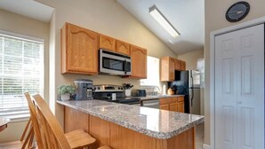 A kitchen with wooden cabinets, a granite countertop, a microwave, a stove, and a refrigerator. - 24-6 Serenity Escape Penthouse w/Indoor/Outdoor Pool / Splash Pad Near SDC (Branson)
