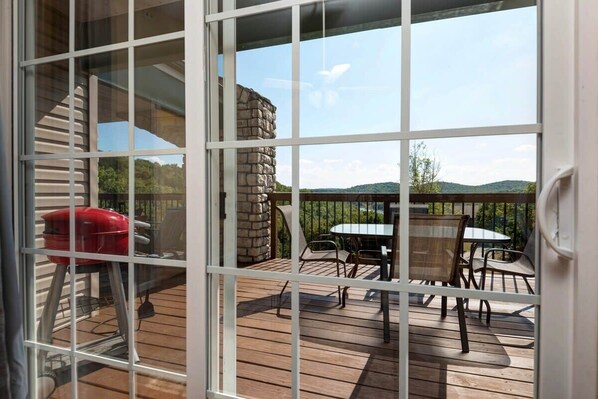 Una terraza con muro de piedra, una parrilla y mobiliario exterior.