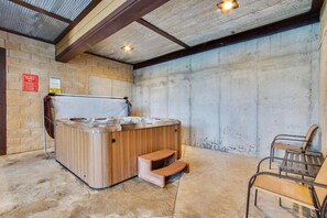 Un jacuzzi con escalones de madera, una silla y un muro de hormigón.