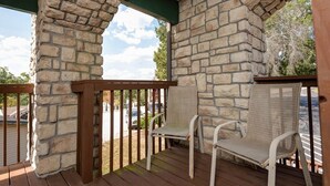 A covered outdoor area with stone walls and wooden railings, featuring two wicker chairs. - 24-6 Serenity Escape Penthouse w/Indoor/Outdoor Pool / Splash Pad Near SDC (Branson)
