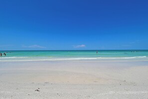 A beach with clear turquoise water and a sandy shore. - Location! Location! Location! Steps to Siesta Key Beach and many shops! (Sarasota)