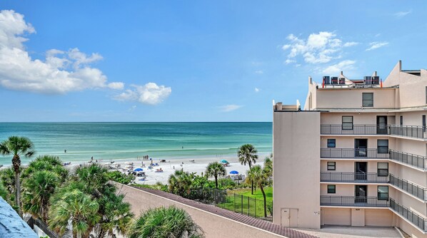 A beachfront hotel with a view of the ocean, a sandy beach, and palm trees. - Location! Location! Location! Steps to Siesta Key Beach and many shops! (Sarasota)