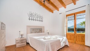 A bedroom with a bed, nightstands, a wall art piece, and a large window with a view. - FRANCISCA  Ref. VP03 (Alcúdia)