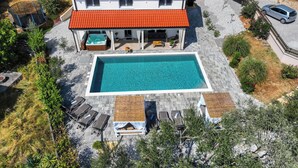 Et toetagers hus med swimmingpool, udendørs møbler og en have.