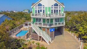 A multi-level beach house with a pool, a balcony, and a sign indicating 'Queen Anne's Revenge'.