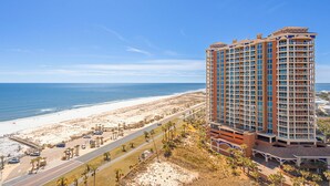 Un hôtel de grande hauteur doté de nombreux balcons donnant sur une plage.