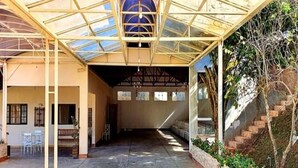 An open courtyard with a glass roof, a staircase, and a seating area with chairs.