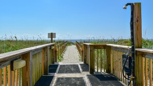 Un muelle de madera que conduce a una playa bajo un cielo despejado.