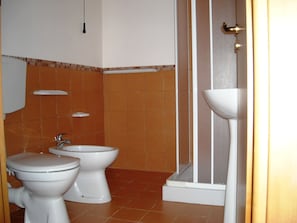 A bathroom with two toilets, a sink, and a shower. - Cozy Studio Erato ideal for a couple (Menfi)
