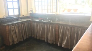 Una cocina con un lavaplatos integrado, una ventana con vistas y un suelo de piedra.