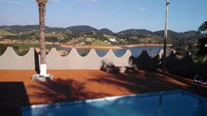 Una piscina con vista a una playa y colinas.