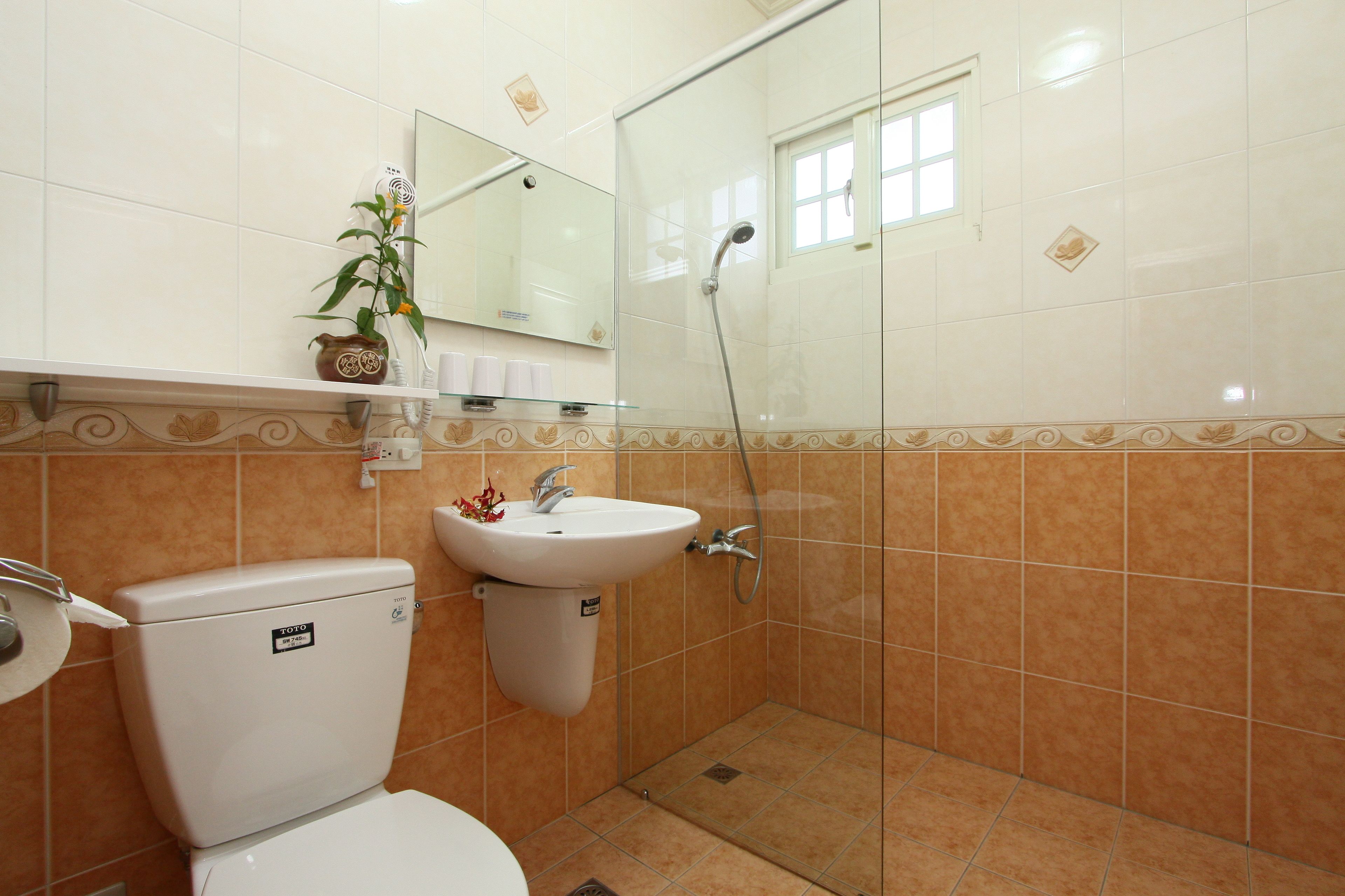 A bathroom with a toilet, sink, and shower.