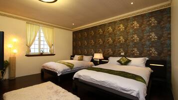 A hotel room with two beds, a large window with curtains, a wall with a floral pattern, and a standing lamp.